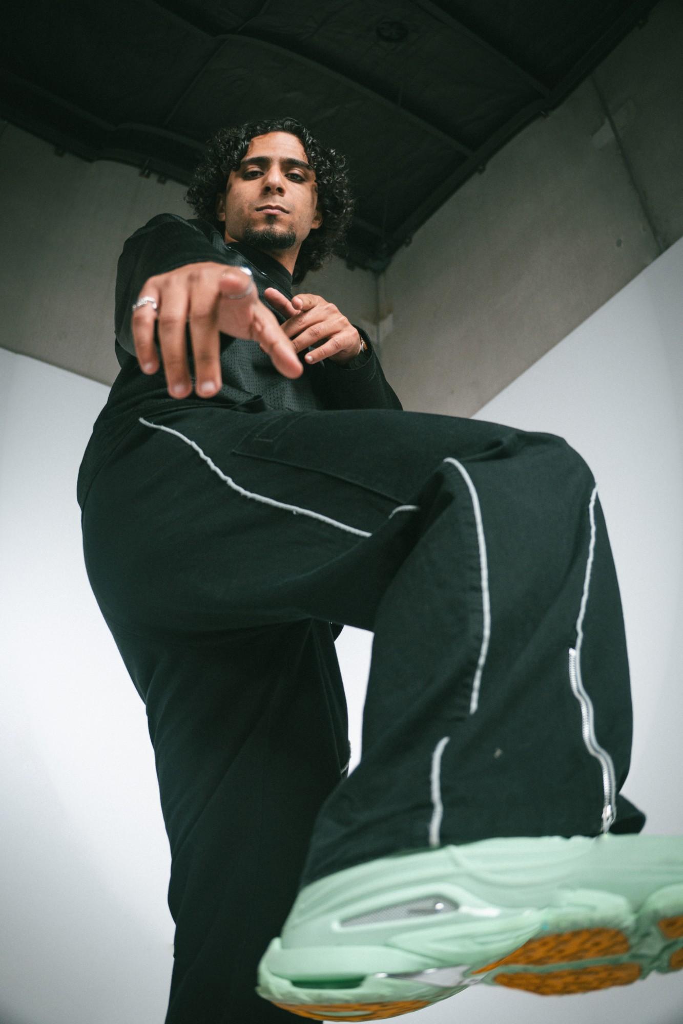 A young man from GenJ in black, pointing at the camera from a low angle